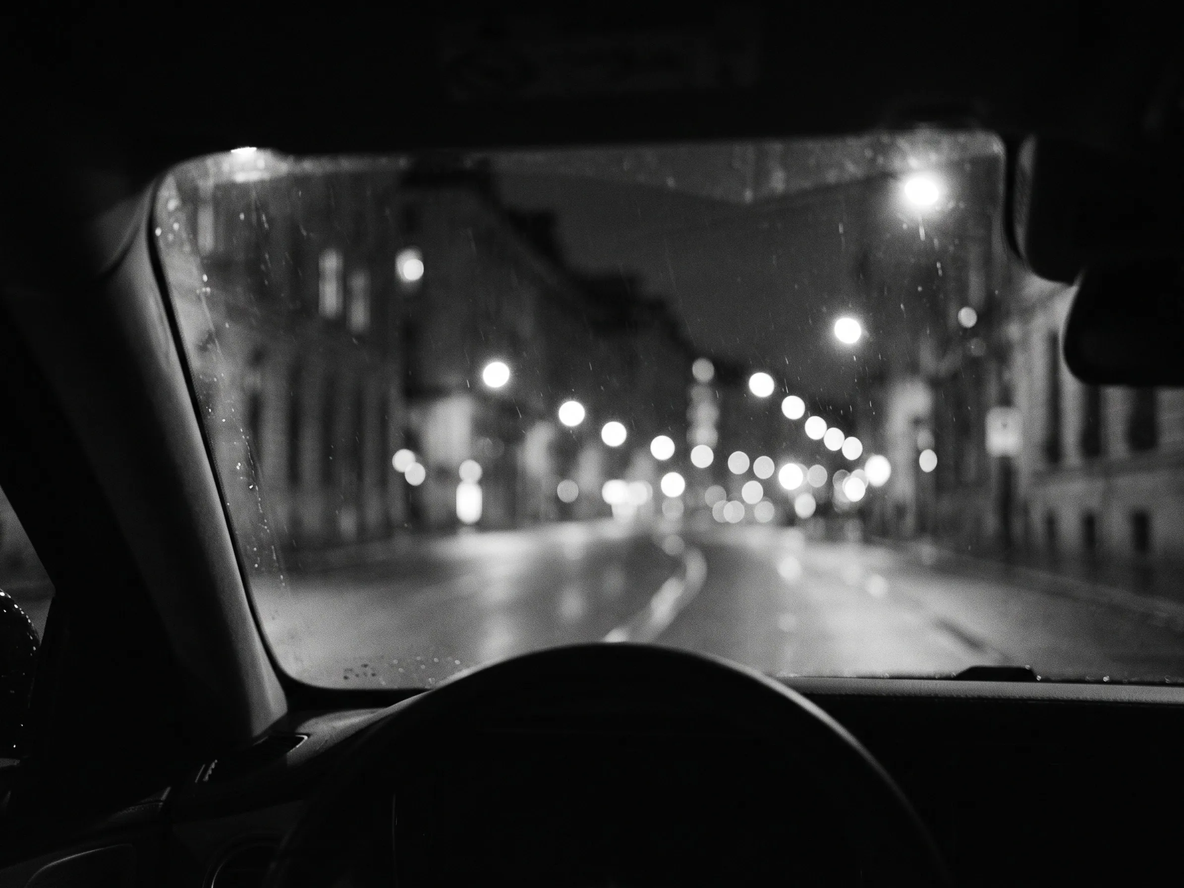 Vista nocturna de avenida a través del parabrisas
